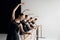 Beautiful talented teen girls, ballet dancers in black costumes standing at barre and practicing with focus and