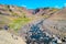 Beautiful and tall Icelandic waterfall Hengifoss with hikers hiking the trail, Iceland, at sunny day and blue sky, summer