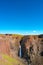 Beautiful and tall Icelandic waterfall Hengifoss and hiking trail to it, Iceland, summer, sunny day, blue sky