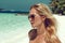 Beautiful tanned woman on maldives island beach with white sand, palms and turquoise sea on background