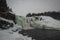 Beautiful Tannforsens waterfall, biggest waterfall in Sweden on a dull cold winter day. Panorama of icy waterfall, but water is