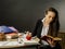 Beautiful teacher sitting at her desk reading