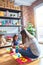 Beautiful teacher and toddler girl playing with construction blocks bulding tower at kindergarten