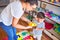 Beautiful teacher and toddler using alarm clock at kindergarden