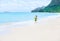 Beautiful teen girl in green dress running on Hawaiian beach