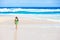 Beautiful teen girl in green dress walking along Hawaiian beach