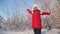 Beautiful teen girl playing in a winter park. happy girl throws up snow with her hands at sunset in forest. Snow falls