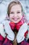 Beautiful teen girl in Russian national clothes with red apples in winter hands