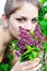 Beautiful teen girl smelling lilac blossoms