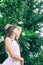 Beautiful teen girl in white dress top with plumeria tree. Boho style portrait