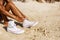 Beautiful teenage black girl in white sneakers on the sand of be