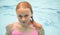 Beautiful teenage blond girl swims in pool