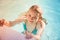 Beautiful teenage blond girl swims in pool