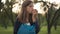 Beautiful teenage girl eating healthful vitamin apple in slow motion at sunset in park. Portrait of pretty Caucasian