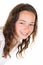 Beautiful teenage girl with mysterious smile posing indoors at blank white studio background