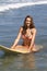 Beautiful Teenage Girl Sitting on a Surfboard