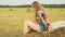 Beautiful teenage girls sitting on haystack and jumping on field