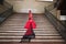 A beautiful teenage woman dancing flamenco goes up the stairs clutching a fringed and embroidered shawl in her hand. She is