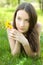 Beautiful teenager with dandelion on lawn