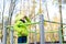 Beautiful teenager daughter in an green jacket plaing on the playground in the autumn park. Horizontal photo