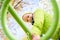 Beautiful teenager daughter in an green jacket plaing on the playground in the autumn park. Horizontal photo