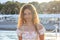 Beautiful teenager girl in the rays of the setting sun on a pier by the sea