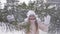 Beautiful teenager girl rejoicing winter snowfall in snowy forest slow motion