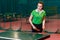 A beautiful teenager girl in sports form makes a serve in table tennis in the gym. ping pong