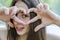 Beautiful teenager relaxed on her holidays making a heart gesture