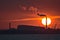 Beautiful telephoto view of epic orange sunset over Dublin port and Sun aligned with Covanta Plant Dublin Waste to Energy