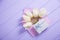 Beautiful tender bouquet of white tulips in envelope with gift box on lilac wooden background