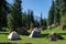 Beautiful tents in mountains near rive. Trekking, camping concept. Beautiful summer landscape. Base camp in beautiful mountain