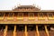 Beautiful Thai style wooden building with multiple windows with golden frames in a Buddhist temple in Thailand.