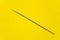 Beautiful thin elegant needle on a yellow background.