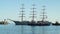 A beautiful three-sailing ship is sailing to the port and it is accompanied by two towing boats in Yalta 4k