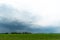 A beautiful thundercloud with rain hovered over a field of wheat. A terrible black cloud on the eve of a tornado and a natural