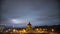 Beautiful time lapse: massive clouds floating night city sky. Orthodox church on foreground and lightened TV tower on background.