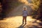 Beautiful toddler boy, walking on rural path on sunset, backlit