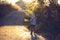 Beautiful toddler boy, walking on rural path on sunset, backlit