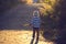 Beautiful toddler boy, walking on rural path on sunset, backlit