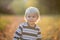 Beautiful toddler boy, walking on rural path on sunset, backlit