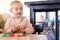 Beautiful toddler child girl sitting on baby highchair  playing with toys on the table