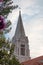 Beautiful top of the belltower of an old church in the village of Selca , on the island of Brac in Croatia. Vertical shot of a