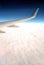 Beautiful top view from passenger supersonic airplane window flying high above white clouds in the sky