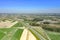 Beautiful top view of plowed and sown fields that intersect the highway. Shot on a drone.