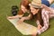 Beautiful tourist ladies lying on green grass