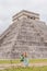 Beautiful tourist woman and her son observing the old pyramid and temple of the castle of the Mayan architecture known