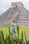 Beautiful tourist woman observing the old pyramid and temple of the castle of the Mayan architecture known as Chichen