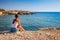 Beautiful tourist woman on the old castle on Mediterranean sea coast. Paphos, Cyprus. Bright sunset light