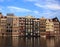 Beautiful traditional old buildings at day with bright blue sky in Amsterdam, the Netherlands